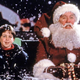 Santa (Tim Allen) and his son sit in the snow in the Santa Clause.